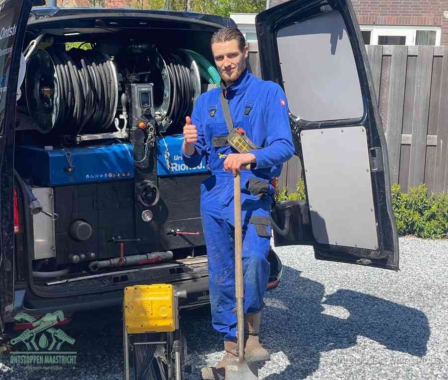 Een tevreden monteur met opgestoken duim naast de bestelbus, slim ingrijpen bespaart kosten bij een verstopte afvoer in Maastricht