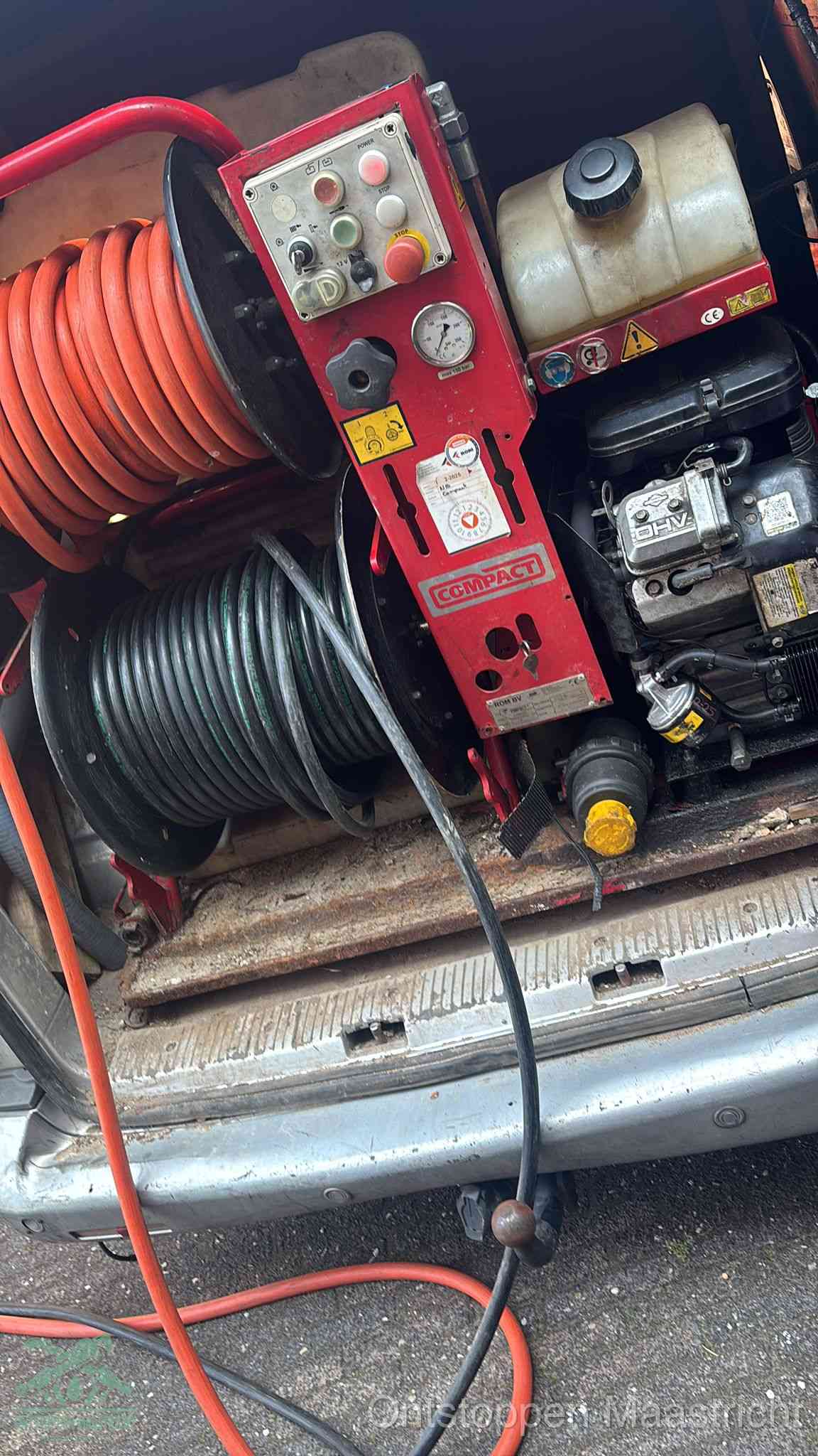 Een rood hogedruk-rioolreinigingstoestel in de laadbak van de bedrijfsbus, apparatuur voor een hardnekkige afvoerverstopping in Maastricht