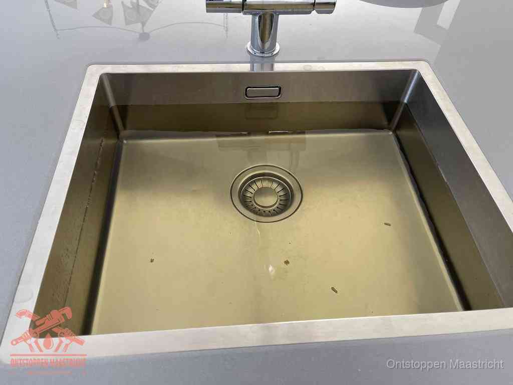 Stilstaand water in een rvs spoelbak dat niet wegloopt, een duidelijk signaal van een gootsteenverstopping in Maastricht