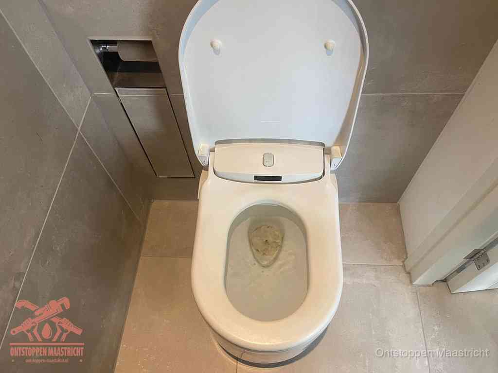 Een wit hangtoilet waarin een prop wc-papier op het water blijft drijven, een duidelijk signaal van een verstopte wc in Maastricht